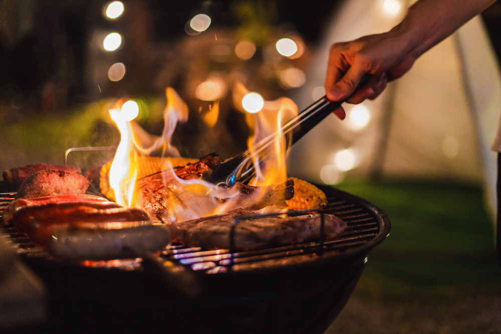 Person grilling meat on a grill