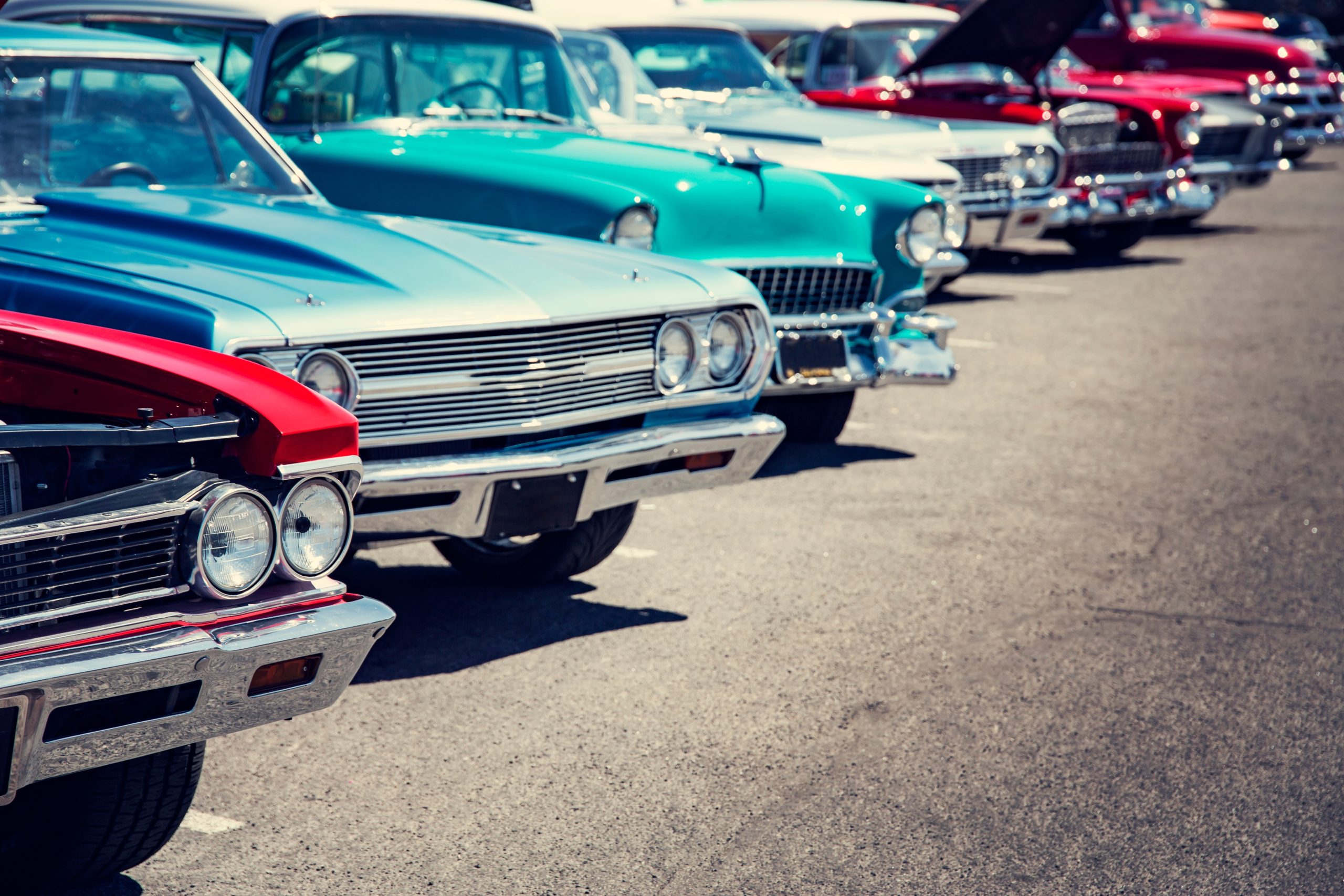 A row of classic cars at a car show.