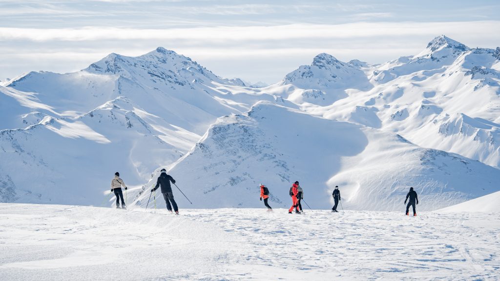 a group of people skiing on a snowy mountain in winter in denver