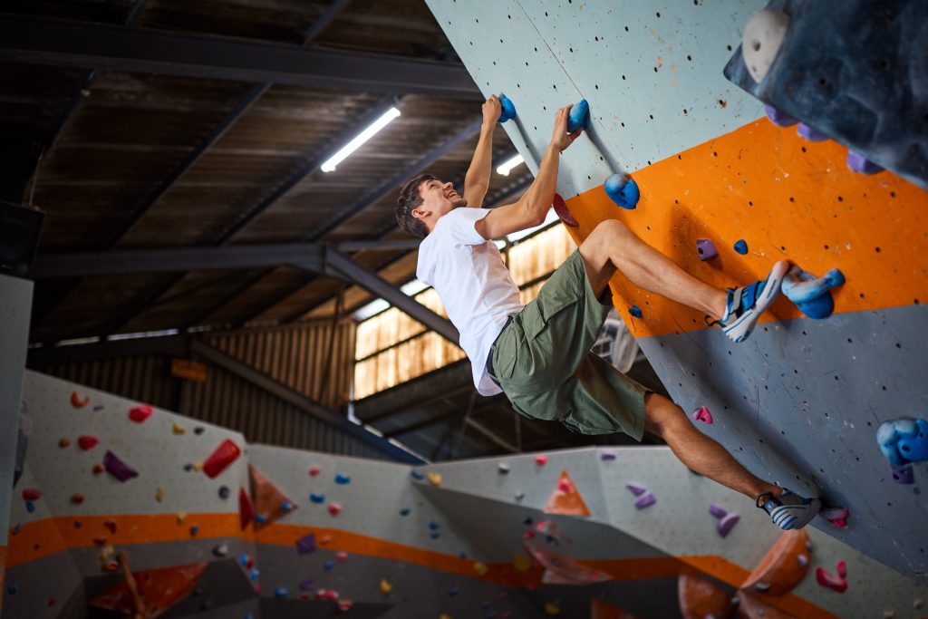 man climbing an indoor climbing wall