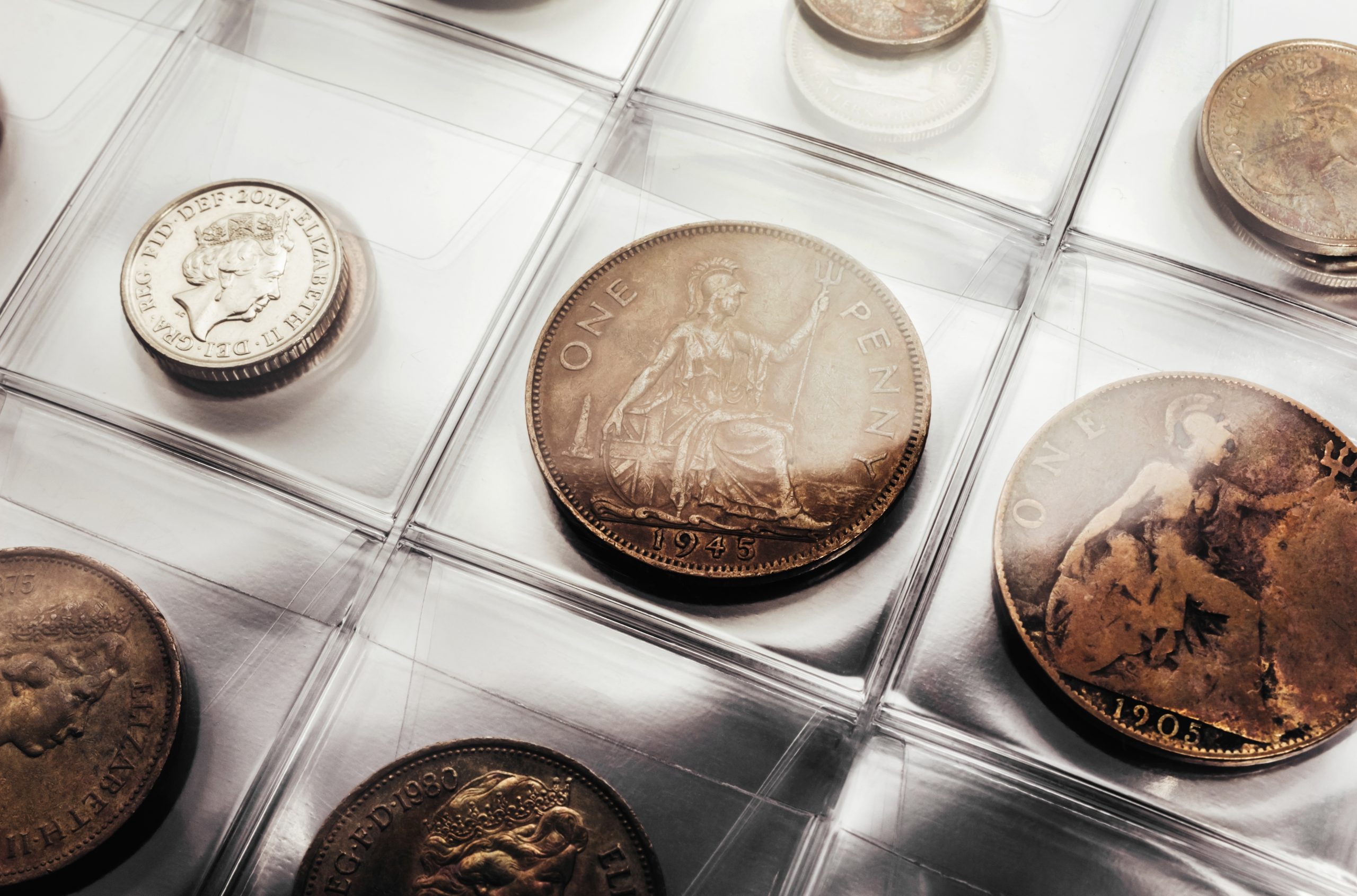 Old and valuable coins in a glass collection case.