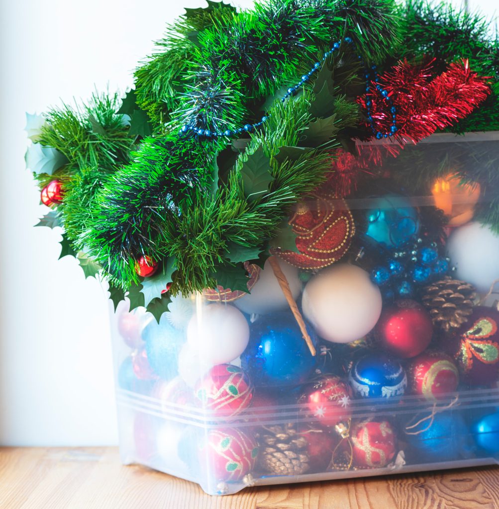 A clear storage container filled with holiday decorations.