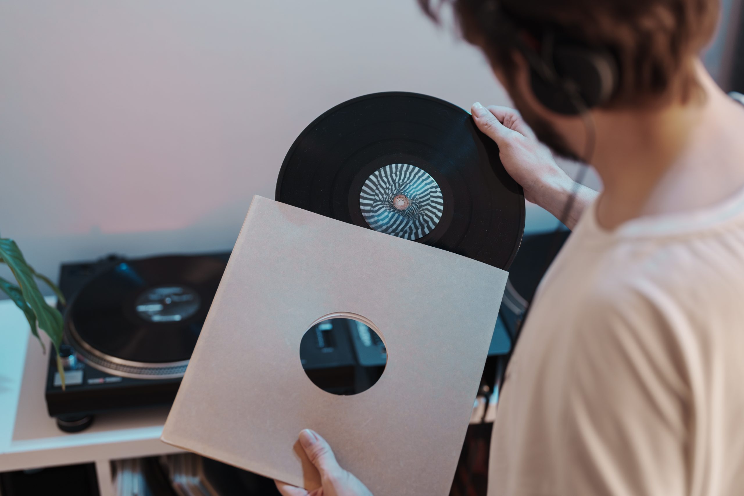 A person taking a vinyl record from its sleeve.