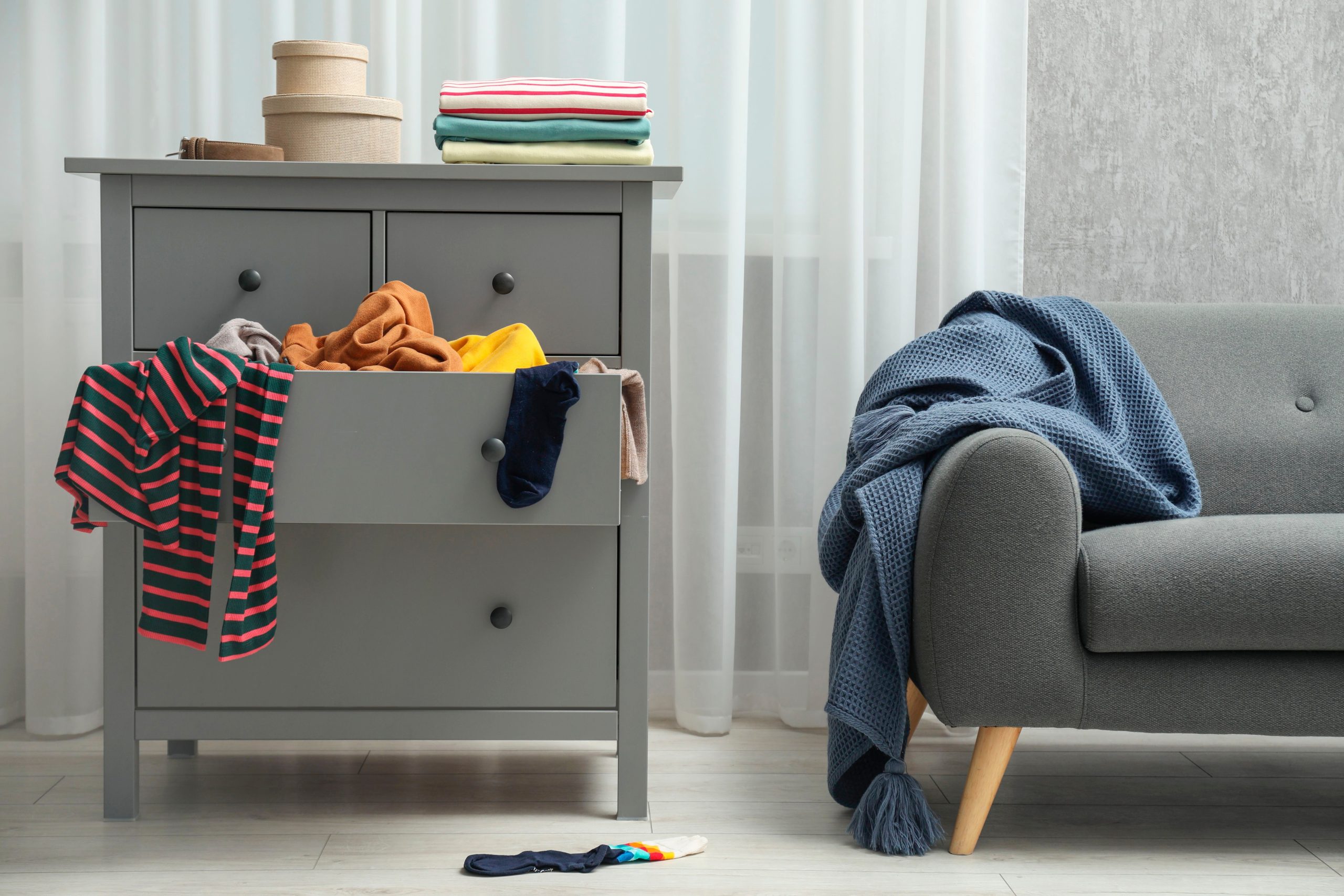 A messy couch and side table.