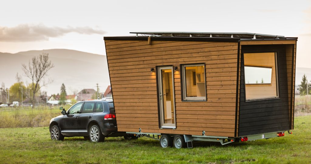 A tiny home hooked up to an SUV.